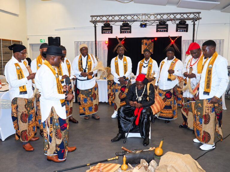Community members gathered around a seated participant during cultural rites